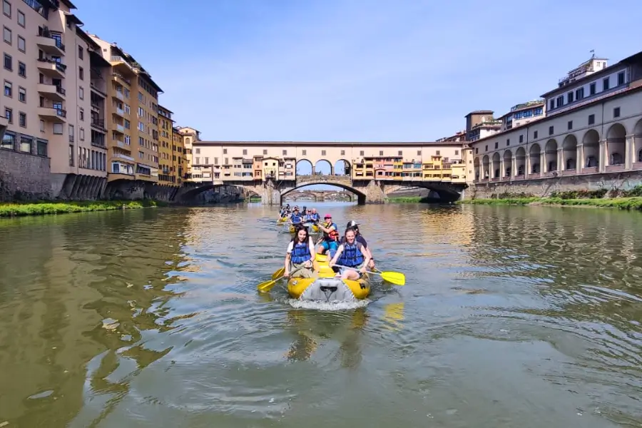 Un gruppo di persone in gommone lungo l'Arno a Firenze durante l'esperienza di Team Building Urban Trekking organizzata da WeHike
