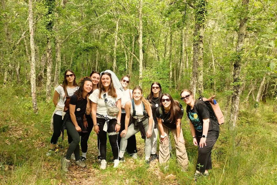 Gruppo di amiche in escursione tra boschi e vigneti del Chianti per un addio al nubilato nella natura.